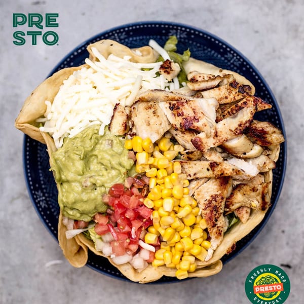 A Presto Fresh Cafe chicken taco salad with guacamole, corn, pico de gallo, and cheese.